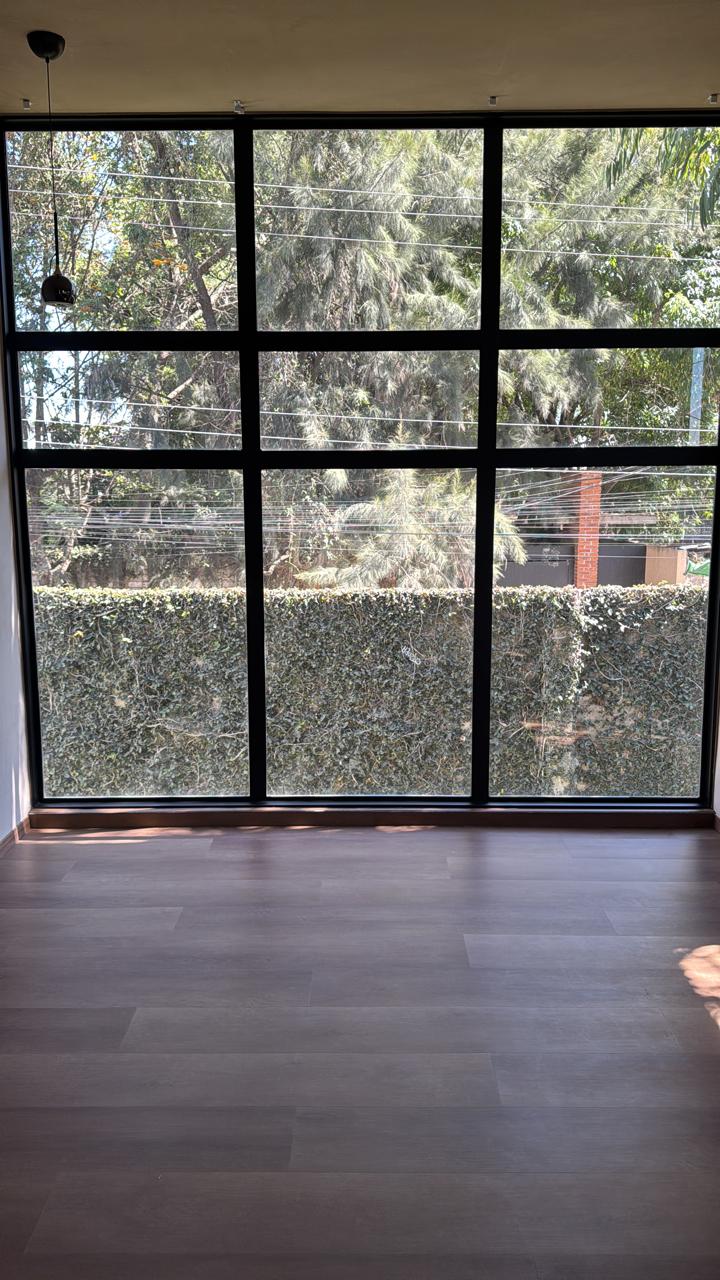 Ventanal de piso a techo con vista al jardín
